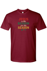 Light Maroon t-shirt with 'Jesus is the Reason for the Season' text in red, green, and yellow color and a holly design underneath. Jesus Christian Christmas T-Shirt Short Sleeve.